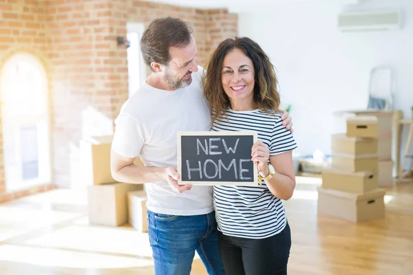 Pareja mayor de mediana edad mudándose a una nueva casa, sonriendo feliz en — Foto de Stock