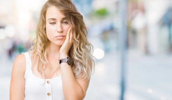 年轻美丽的金发女人在孤立的背景下思考看累了 厌倦了与交叉臂抑郁症问题 — 图库照片