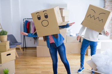 Çılgın çift kafa üzerinde komik yüzler ile kutuları giyiyor, yeni bir eve taşımak için mutlu eğlenceli