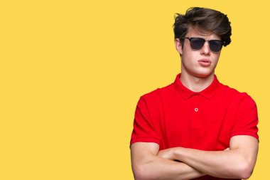 Genç yakışıklı adam izole arka plan şüpheci ve sinir, onaylamayan ifade yüz çapraz kolları üzerinde güneş gözlüğü takıyor. Negatif kişi.