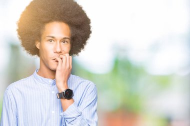 Afrikalı-Amerikalı genç afro saçlı stresli ve gergin elle çivi ısırma ağzına bakıyor. Anksiyete sorunu.