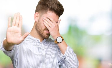 Genç yakışıklı adam kapsayan gözleri elleriniz ve üzgün dur jestle yapıyor ve korku ifadesi. Utandım ve negatif kavramı.