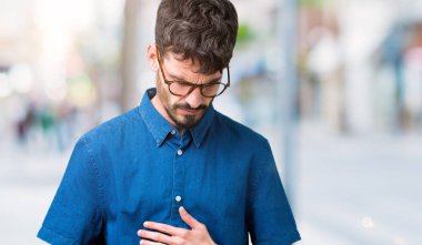 Yakışıklı delikanlı üzerinde gözlük takan izole mide üzerinde el ile arka plan çünkü mide bulantısı, ağrılı hastalık hasta hissediyor. Ağrısı kavramı.