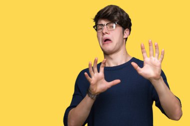 Şokta bağırarak korkuyor ve dehşet korku ifade dur hareketi el ile ile izole arka plan üzerinde gözlük takan yakışıklı delikanlı. Panik kavramı.