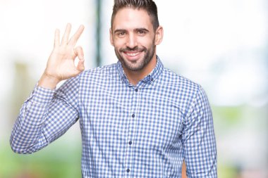 Gülümseyen izole arka plan üzerinde genç yakışıklı adam el ve parmaklar ok işaretiyle yapıyor olumlu. Başarılı ifade.
