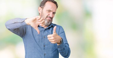 Yakışıklı orta yaş izole arka plan yapmaya başparmak yukarı ve aşağı, anlaşmazlık ve anlaşma ifade üzerinde zarif komuta sizde. Deli çatışma