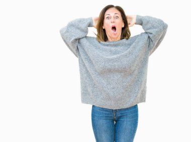 Güzel orta yaş kadın giyiyor kış kazak üzerinde arka plan deli izole ve baş, korkuyor ve açık ağzı ile şok sürpriz elleriyle korkuttu