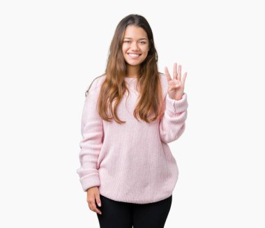 Gösterilen ve parmakları ile işaret izole arka plan üzerinde pembe kış kazak giyen genç güzel esmer kadın kendinden emin ve mutlu gülümseyerek süre dört numara.