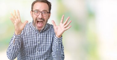 Üzerinde gözlük takan yakışıklı orta yaş zarif komuta sizde deli kutluyor arka plan izole ve silah ile başarı için yükseltilmiş ve açık gözleri heyecanlı çığlık hayrete düşürdü. Kazanan kavramı