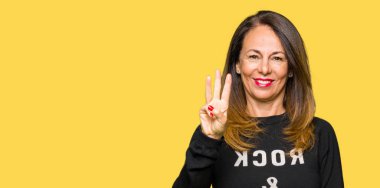 Güzel orta yaş kadın giyiyor rock'n roll kazak gösterme ve parmakları ile işaret üçüncüsü ise kendinden emin ve mutlu gülümseyerek.