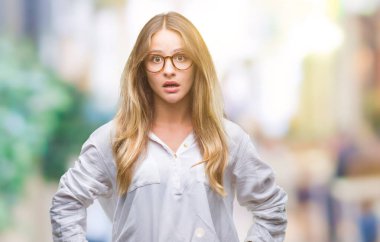 Arka plan korkuyor ve şok sürpriz ifade, korku ve heyecan yüz üzerinden gözlüklü genç güzel sarışın iş kadını izole.