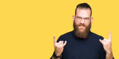 Deli ifade rock simge elle yapıyor ile gözlük ve balıkçı yaka kazak bağırarak giyen genç sarışın adam. Müzik yıldızı. Ağır kavramı.