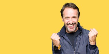 Orta yaş yakışıklı adamın bir ceket kutluyor giydiğini şaşırttı ve silah ile başarı için yükseltilmiş ve açık gözler hayrete düşürdü. Kazanan kavramı.