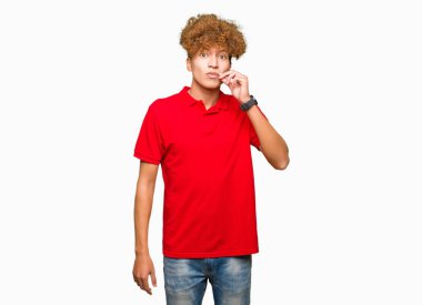 Kırmızı t-shirt ağız ve dudaklar afro saçlı yakışıklı delikanlı olarak ZIP parmak ile kapatın. Gizli ve sessiz, tabu söz