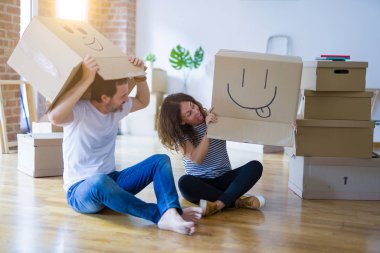 Mutlu yüzleri ile komik karton kutular giyen çift, hareket