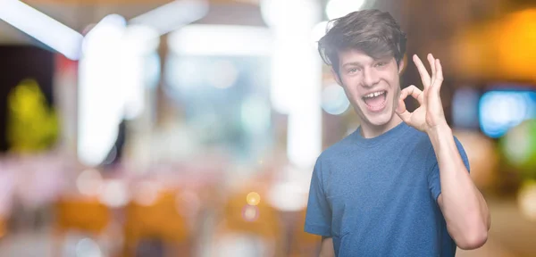 Pemuda Tampan Mengenakan Kaos Biru Atas Latar Belakang Terisolasi Tersenyum — Stok Foto