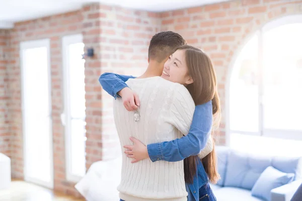 Jeune couple asiatique tenant les clés de la nouvelle maison, souriant heureux et — Photo