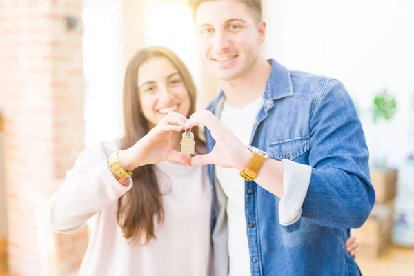 Bella giovane coppia che si abbraccia in amore e mostra le chiavi di nuovo h — Foto Stock