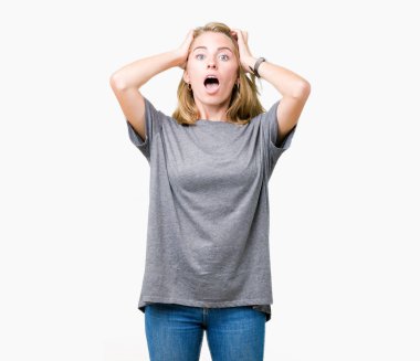 Güzel genç kadın üzerinde büyük boy rahat t-shirt giyen arka plan deli izole ve baş, korkuyor ve açık ağzı ile şok sürpriz elleriyle korkuttu