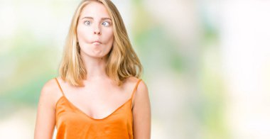 İzole arka plan yapma balık yüzüne dudaklı, çılgın ve komik bir jest turuncu gömlek giymiş güzel ve genç birbayan. Komik ifade.