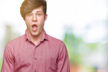 Genç yakışıklı iş adamı izole arka plan korkuyor ve şok sürpriz ifade, korku ve heyecan yüz üzerinden.