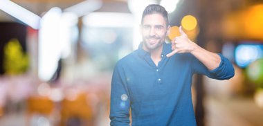 Yakışıklı delikanlı yapıyor gülümseyen izole arka plan üzerinde telefon hareketi ile el ve parmak telefonda konuşuyor gibi. Kavramları iletişim.