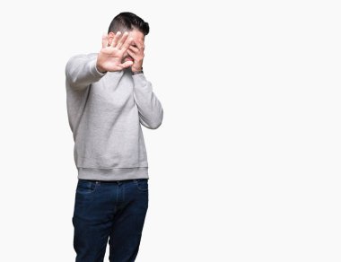 Yakışıklı delikanlı üzerinde sweatshirt giyen izole elleriyle gözlerini kapsayan arka plan ve stop jest ile acı ve korku ifadesi. Utandım ve negatif kavramı.