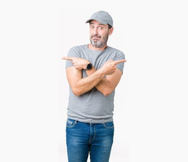 Yakışıklı orta yaş ağarmış komuta sizde Spor şapkası üzerinde arka izole her iki parmak ile işaret eden, farklı yönde katılmıyorum