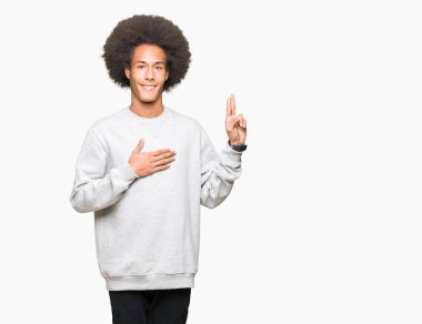 Afro saçlı genç afro-amerikan adam göğüs ve parmakları nda el ile küfür sportif sweatshirt giyen, bir sadakat sözü yemini yapma