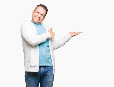 Orta yaş Arap adam izole arka plan gösteren palm el kazak giyen ve yukarıya, mutlu ve neşeli gülümseyen baş parmakları Tamam jest yapıyor