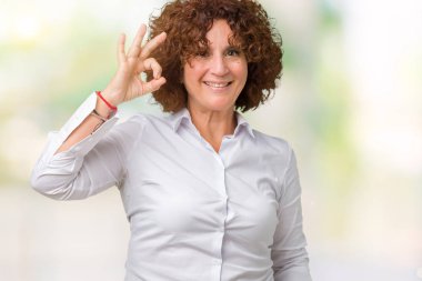 Gülümseyen izole arka plan üzerinde güzel orta ager üst düzey businees kadın el ve parmaklar ok işaretiyle yapıyor olumlu. Başarılı ifade.