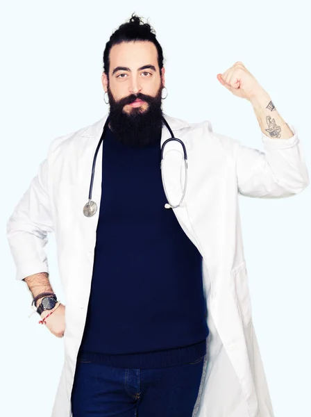 医療コートと腕の筋肉 自信と力の誇りを示す聴診器強い人を身に着けている長い髪の医者 — ストック写真