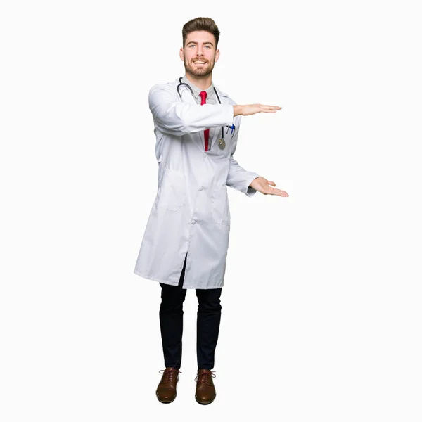 若いハンサムな医者医療コート身振りで示す大きな手と大きなサイズ記号メジャー シンボルを着た男 カメラを見て笑っています 測定概念 — ストック写真