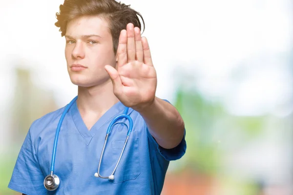 停止を行う分離の背景に医療制服を着て若い医者は 手のひらの上で歌います 顔に否定的な深刻なジェスチャーで警告式 — ストック写真