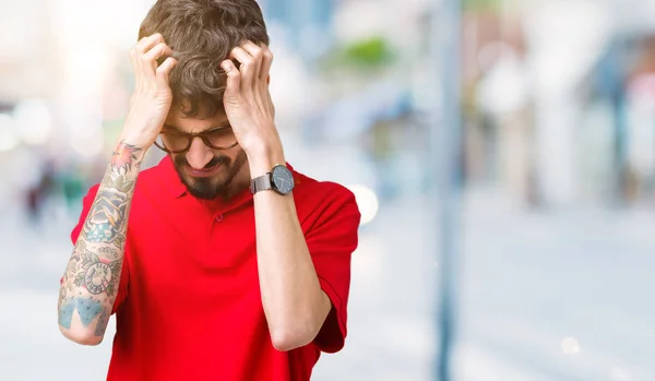 Young handsome man wearing glasses over isolated background suffering from headache desperate and stressed because pain and migraine. Hands on head.