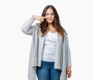 Güzel artı boyutu genç kadın giyiyor kış ceket izole üzerinden yüz ve burun, neşeli gülümseyerek el parmak ile işaret arka plan