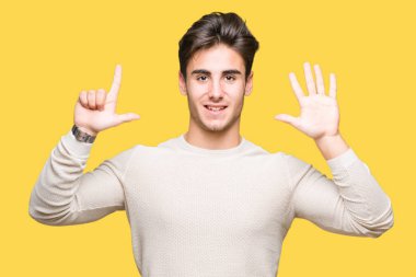 Yakışıklı delikanlı gösterilen ve parmakları ile işaret izole arka plan üzerinde kendinden emin ve mutlu gülümseyerek süre yedi numara.