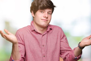 Genç yakışıklı iş adamı izole arka plan clueless ve şaşkın bir ifadeyle kollar ve eller ortaya çıkar üzerinden. Şüphe kavramı.