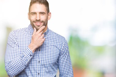 Yakışıklı delikanlı emin çapraz kollar ve çeneme kaldırdı el ile gülümseme ile kameraya bakarak izole arka plan üzerinde. Pozitif düşünce.