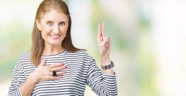 Orta yaş olgun güzel kadın giyiyor çizgili kış kazak izole üzerinde arka plan Swearing göğüs ve bir sadakat sözü yemin yapma parmaklar, el ile