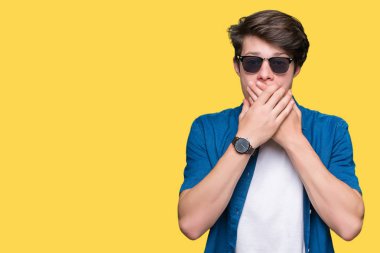 Yakışıklı delikanlı üzerinde güneş gözlüğü takıyor arka plan ağız hata için elleriyle kapsayan şok izole. Gizli kavramı.