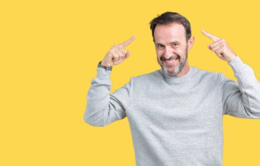 Bir kazak izole üzerinde giyen yakışıklı orta yaş üst düzey adam arka plan hem el parmak, harika bir fikir ya da düşünce, iyi bellek ile baş gösteren gülümseyen