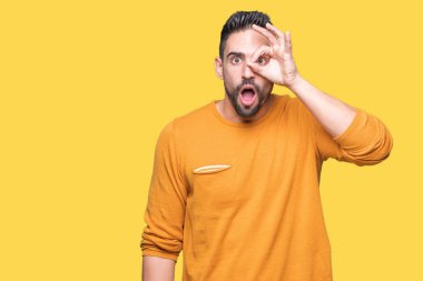 Sürpriz yüz, göz parmaklarının arasından seyir yakışıklı delikanlı ok jest yapıyor izole arka plan üzerinde şok. İmansız ifade.