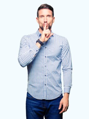 Mavi gözleri olan yakışıklı iş adamı dudaklarında parmak ile sessiz olmak istiyor. Sessizlik ve gizli konsept.