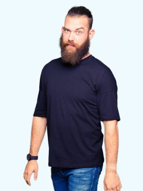 Rahat t-shirt şüpheci ve sinir, papatyanın üzgün sorunu nedeniyle giyen genç sarışın adam. Negatif kişi.