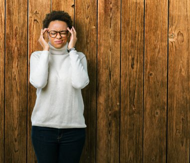 Genç güzel Afrikalı-Amerikalı kadın üzerinde gözlük takan izole arka plan baş baş ağrısı için el ile çünkü stres. Migren muzdarip.