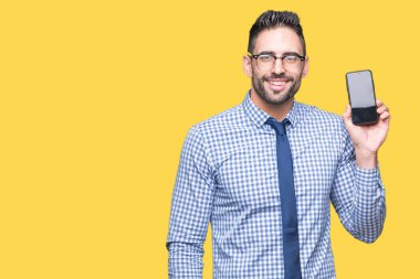 Genç iş adamı gösteren smartphone ekran üzerinde duran ve diş gösterilen kendine güvenen bir gülümsemeyle gülümseyerek mutlu bir yüz ile izole arka plan