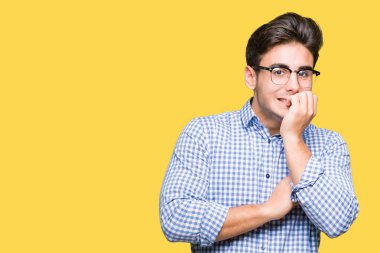 Genç yakışıklı adam stresli ve gergin ile izole arka plan üzerinde gözlük takan tırnak ısırma dudaklarından eller. Anksiyete sorunu.