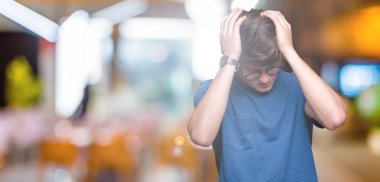 Çünkü çaresiz ve stresli baş ağrısı acı izole arka plan üzerinde gözlüklü genç yakışıklı adam ağrı ve migren. Ellerini kafasına.