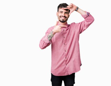 Genç yakışıklı adam izole arka plan üzerinde pembe gömlek giyen mutlu yüzü ile elleri ve parmakları ile çerçeve yapma gülümseyerek. Yaratıcılık ve fotoğrafçılık konsepti.